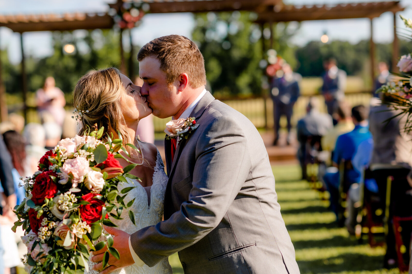 outdoor little rock wedding ceremony venue with bride and groom kissing passionately at the end of the aisle as they exit their ceremony