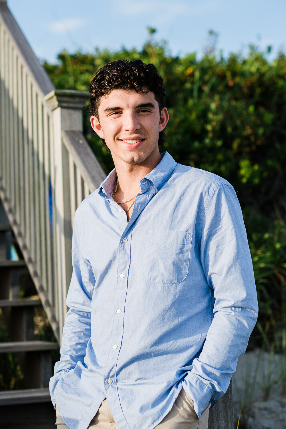 senior boy leaning on railing on stairs