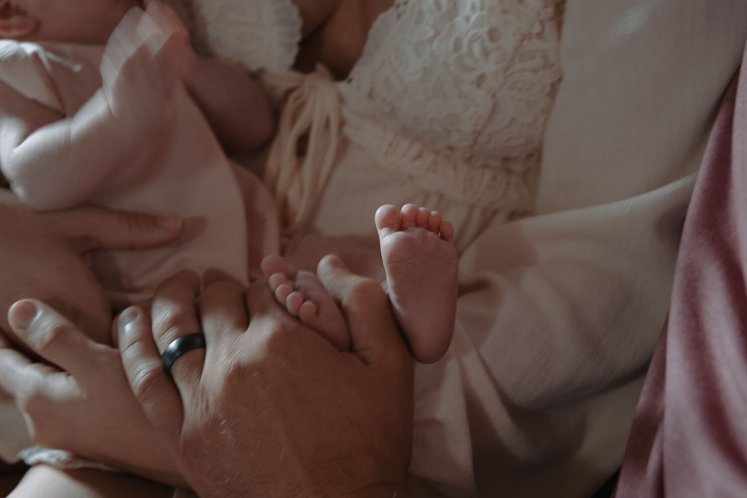 Close-up of newborn baby feet held by parents