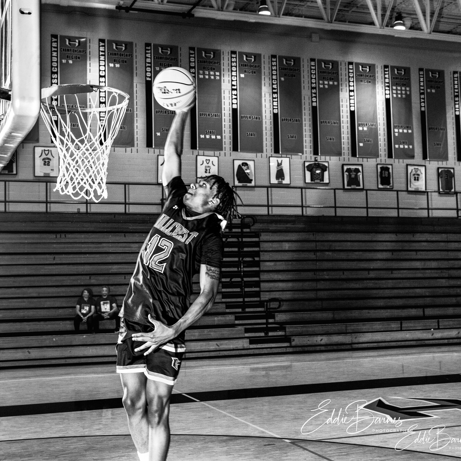 Boy in gyn dunking basketball