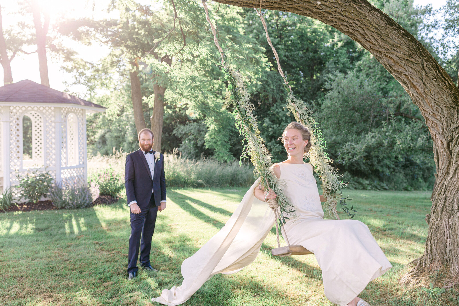 groom pushed bride on an ivy covered tree swing at Windirdge