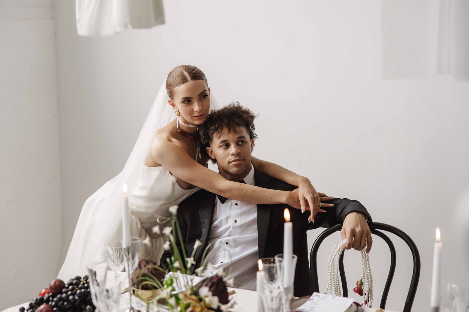 Luxury reception setup with bride and groom posing at the head table.
