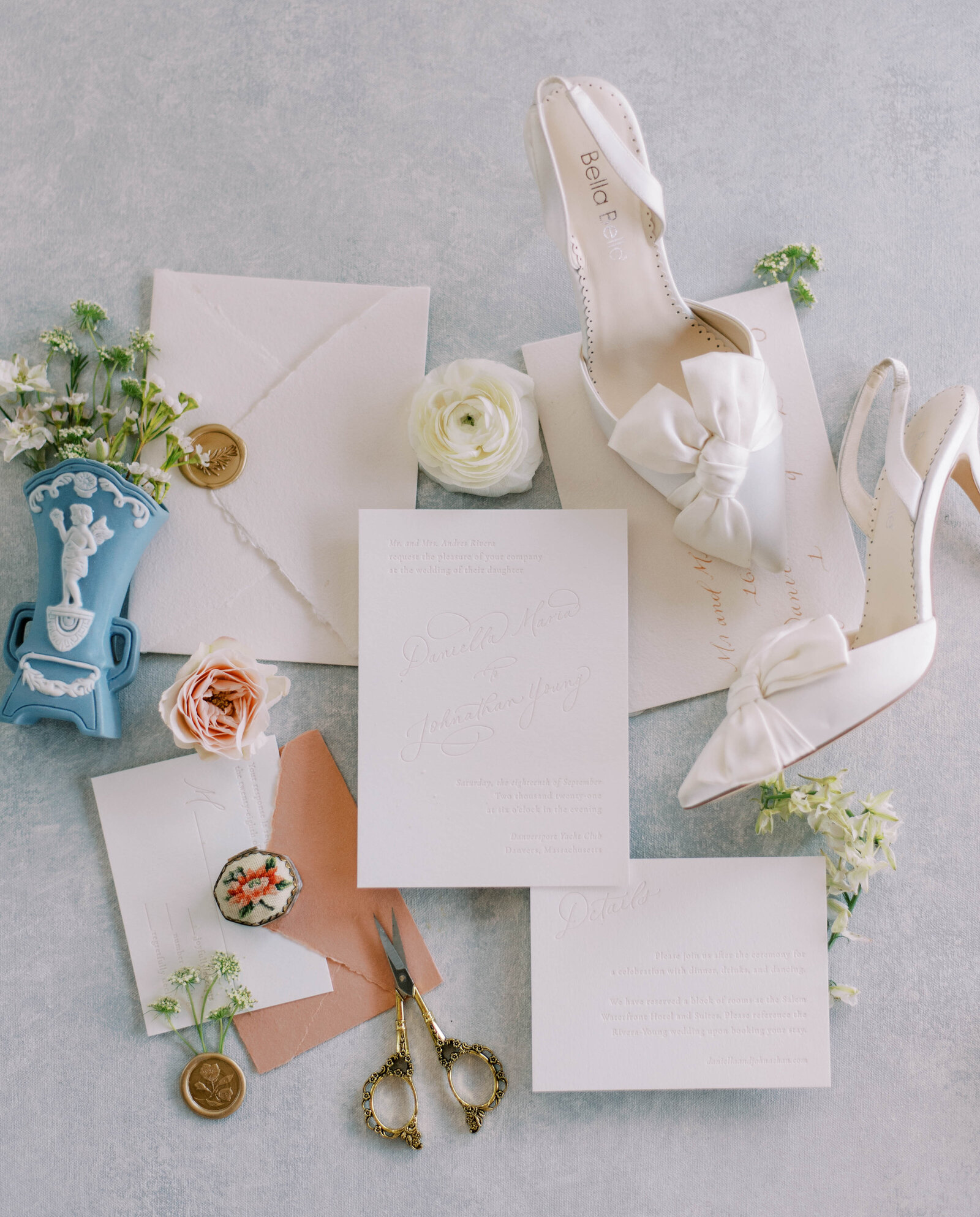 coral, blue, and white flat flay with white bridal shoes at hotel zamora