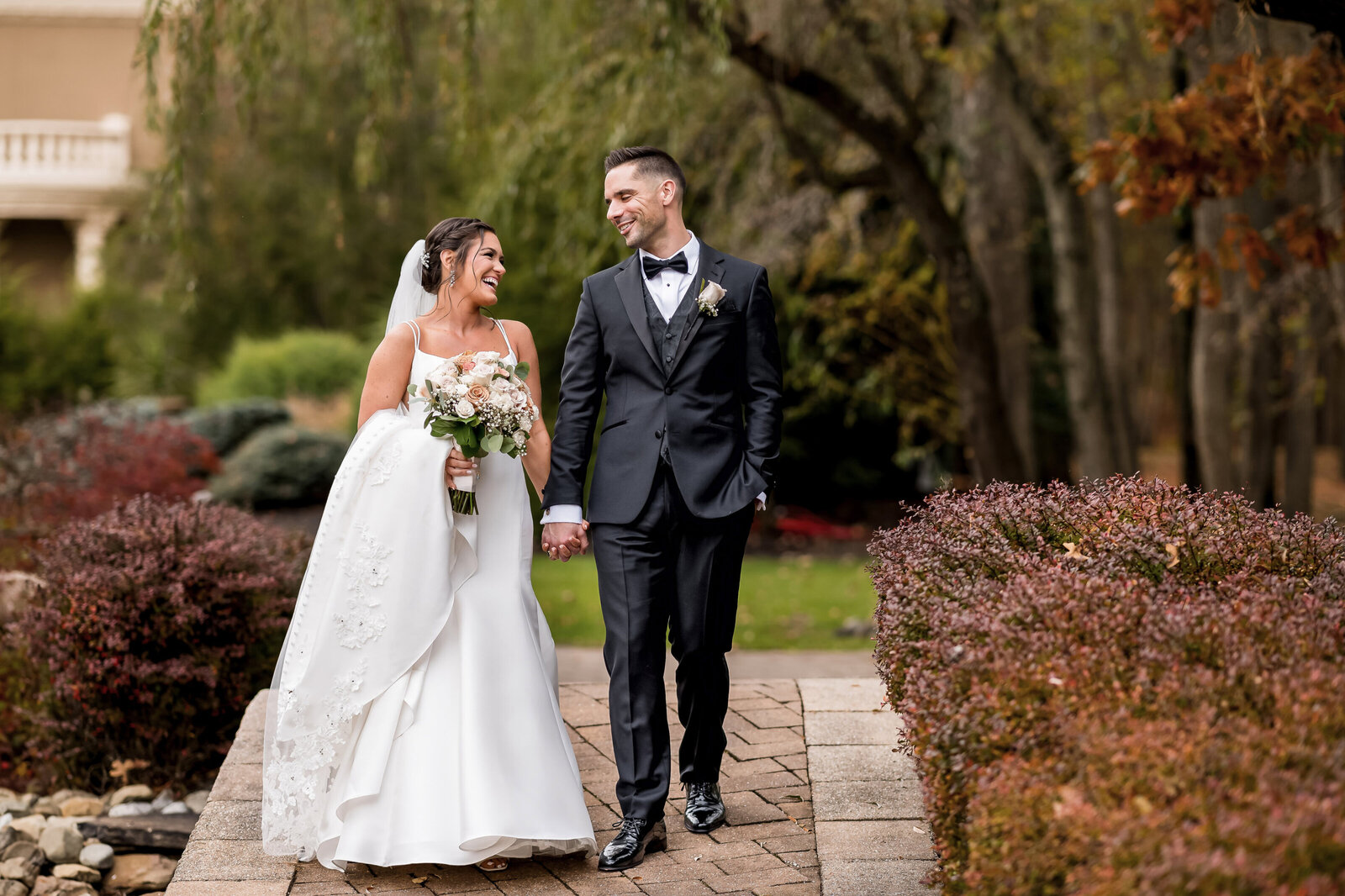bride and groom, walking over a bridge after their first look at Brigalias