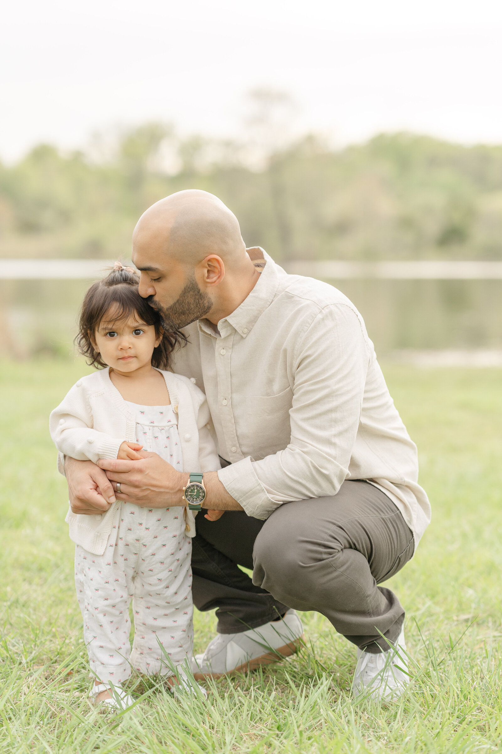 dad kissing daughter on her temple