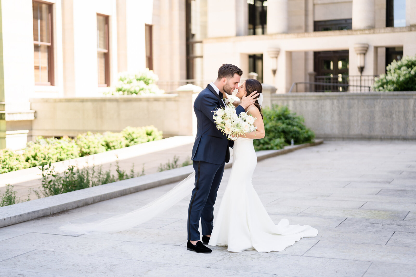 Groom pulls his wife in for a kiss on the landing of the Ohio Statehouse