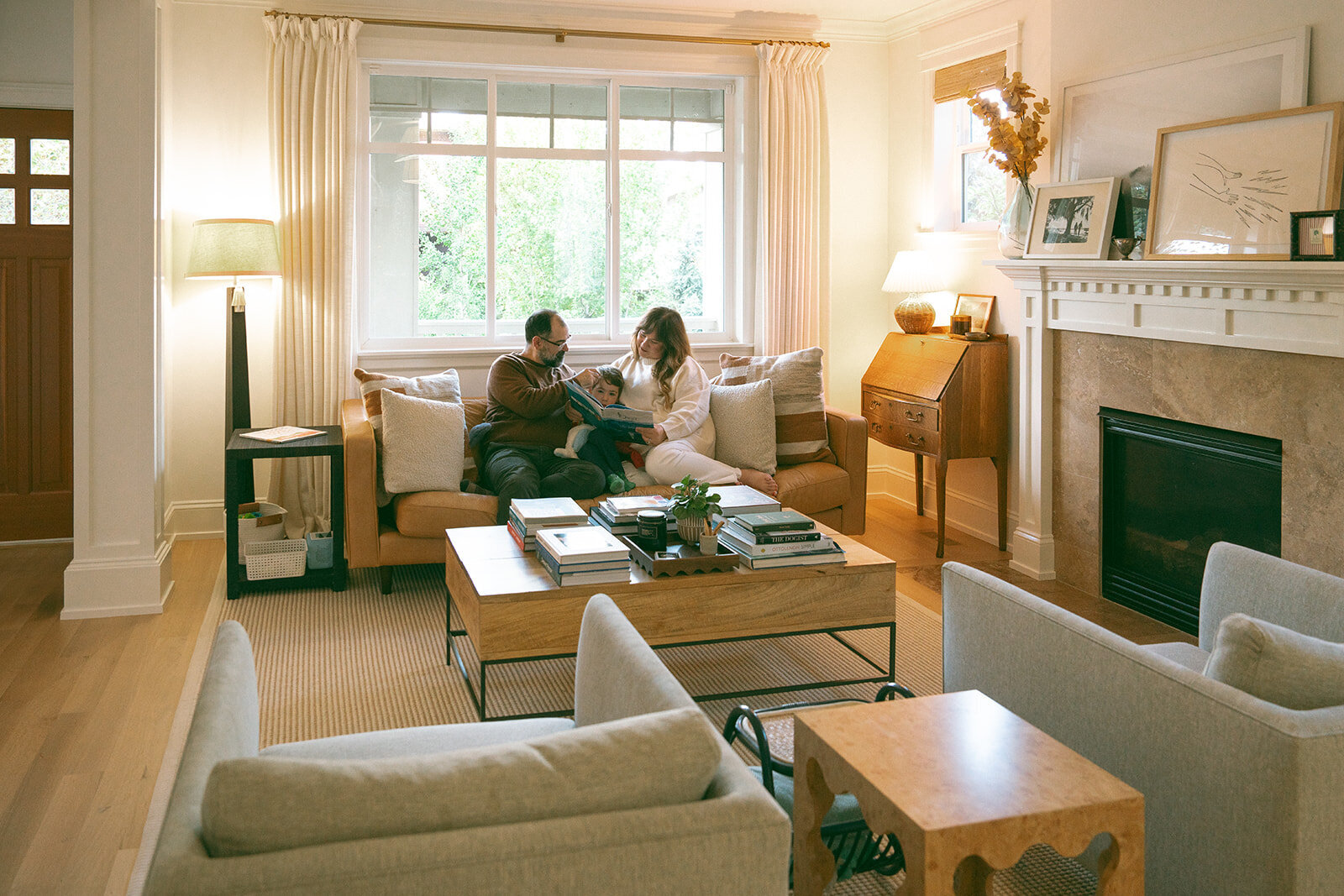 Family sitting together on the sofa reading a book during a lifestyle at-home family photography session in Orange County.