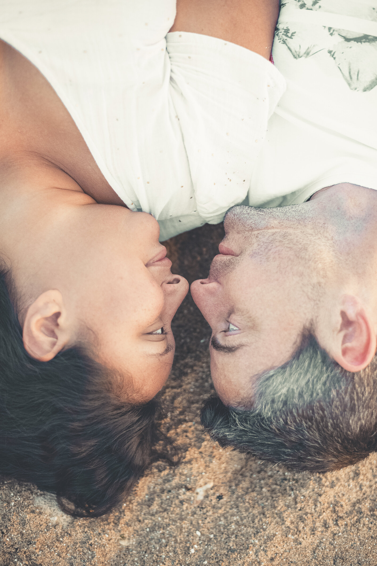 Bisous sur le nez d'un couple qui est allongé sur une plage de Bretagne
