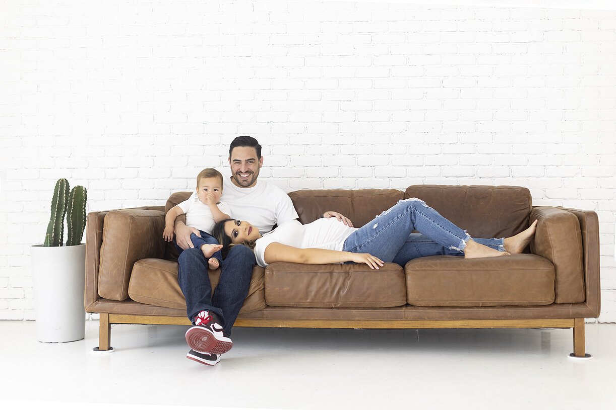Family poses on couch at Lumen Room Plano.