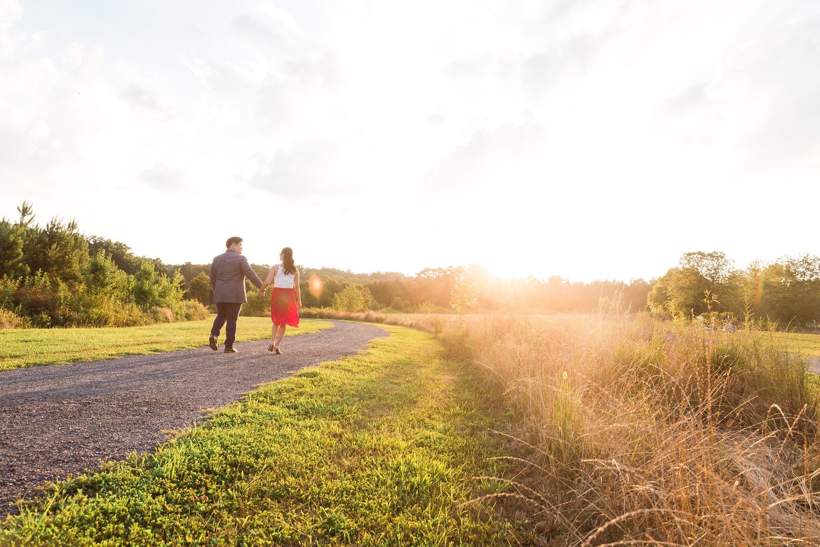Couple walking towards the sunset at a park