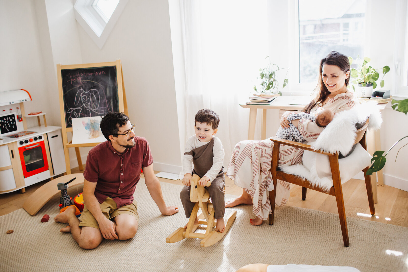 Family playing in homes playroom during newborn photo session