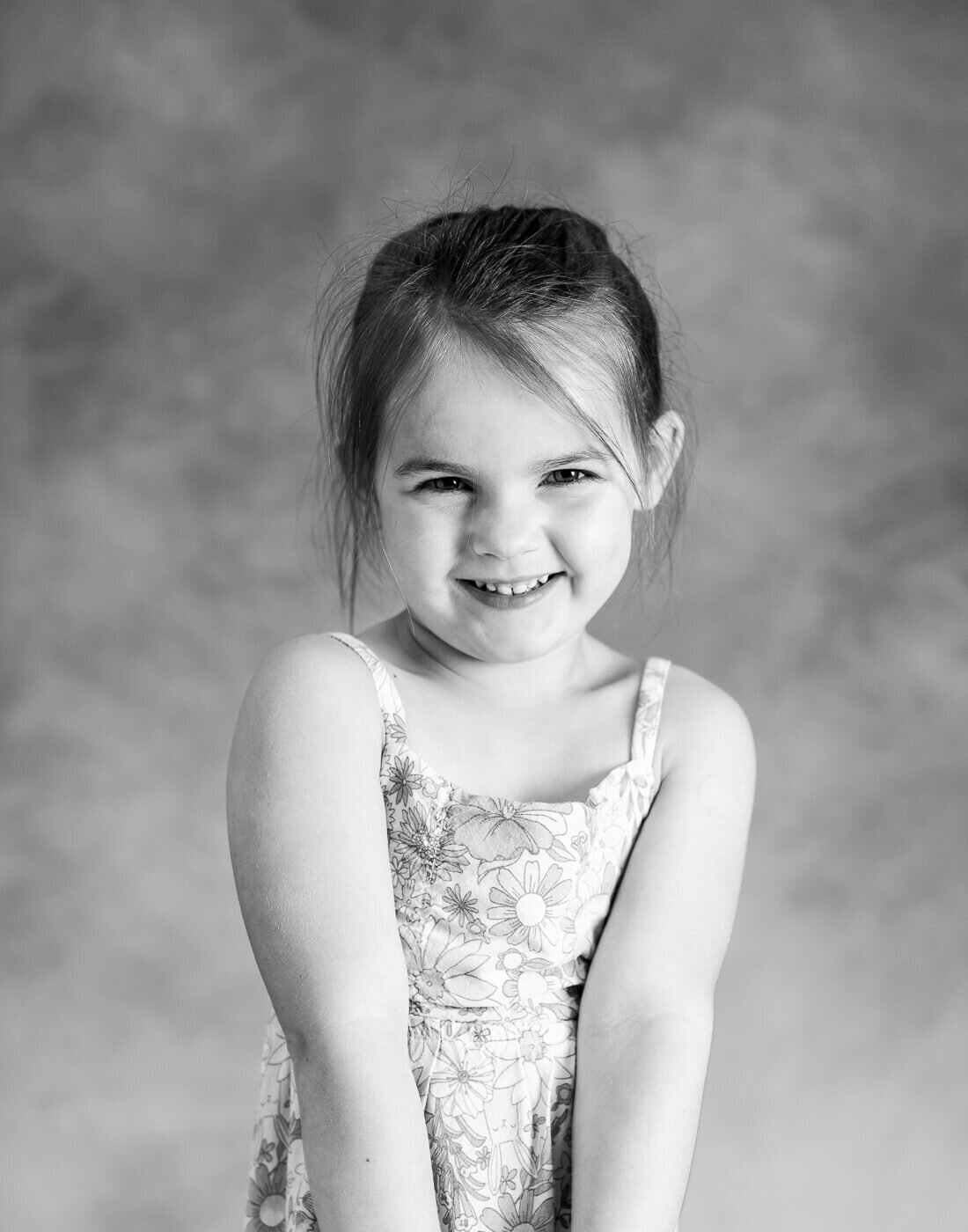 A child smiles in a sundress.