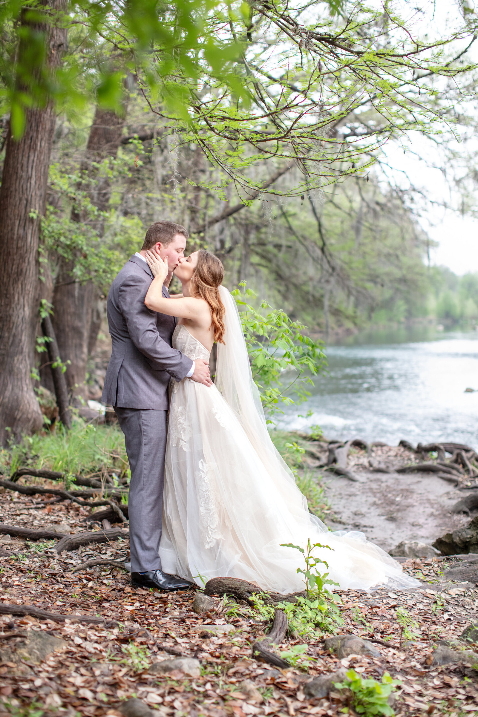 wedding photographer in Texas Firefly couple kissing by river in Gruene