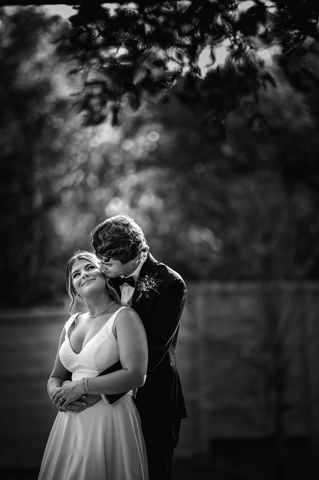 A classic black and white photo of the bride and groom sharing a kiss during their San Antonio wedding, captured by CMH Studios