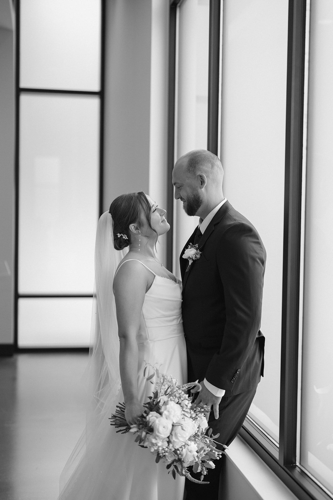 Bride and groom sharing a quiet moment by the window during their elegant Michigan wedding.