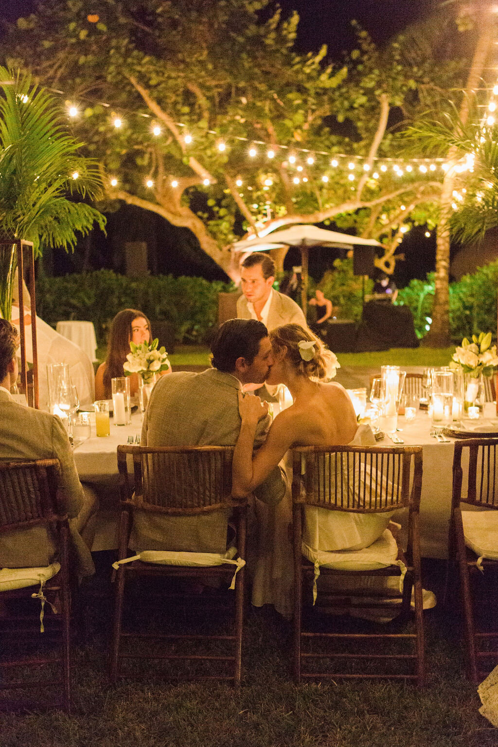 bride and groom kissing at wedding table at destination wedding in Tulum Mexico