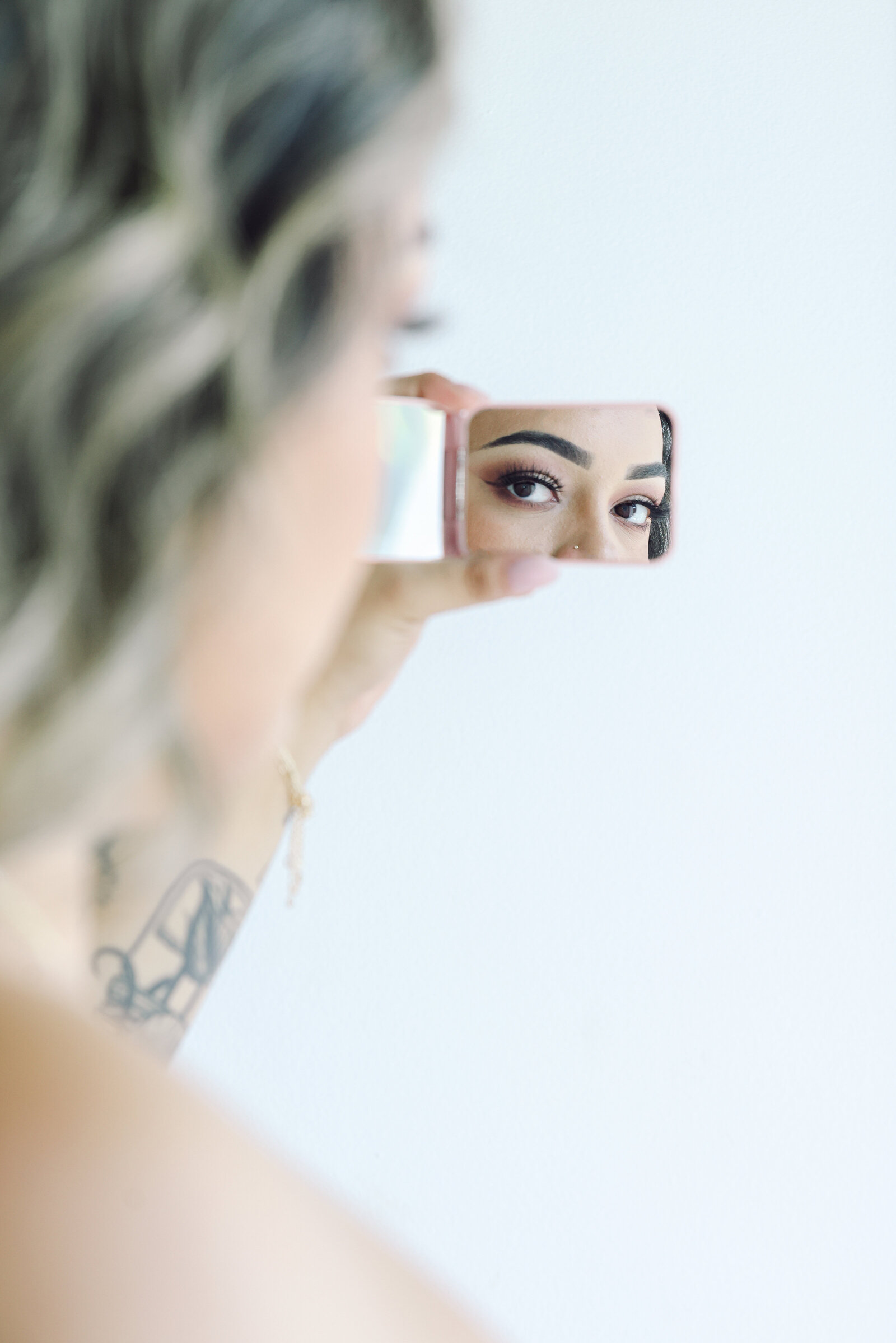 Personal brand photography makeup girl looking into cosmetic mirror