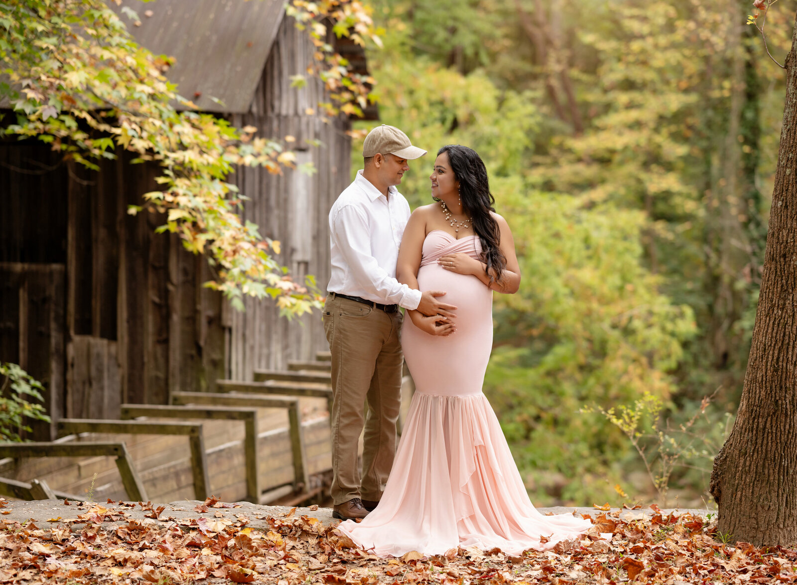 Women in pink maternity dress holding baby bump and looking at dad. Photo taken in marietta Georgia, near Atlanta.