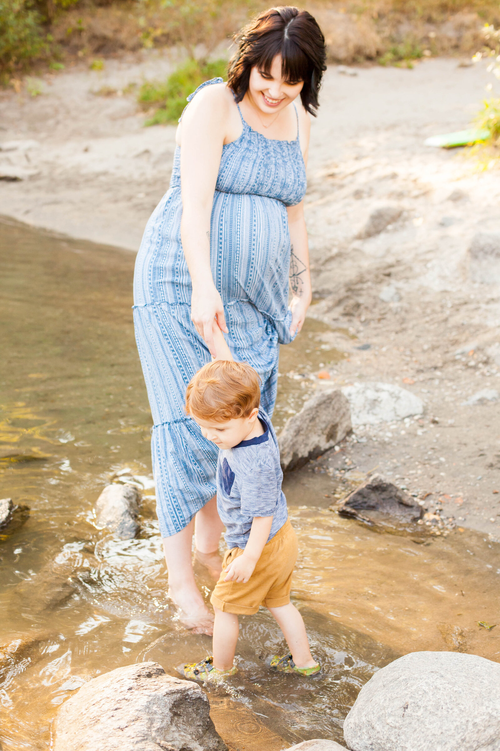 A woman playing with her child in the river.