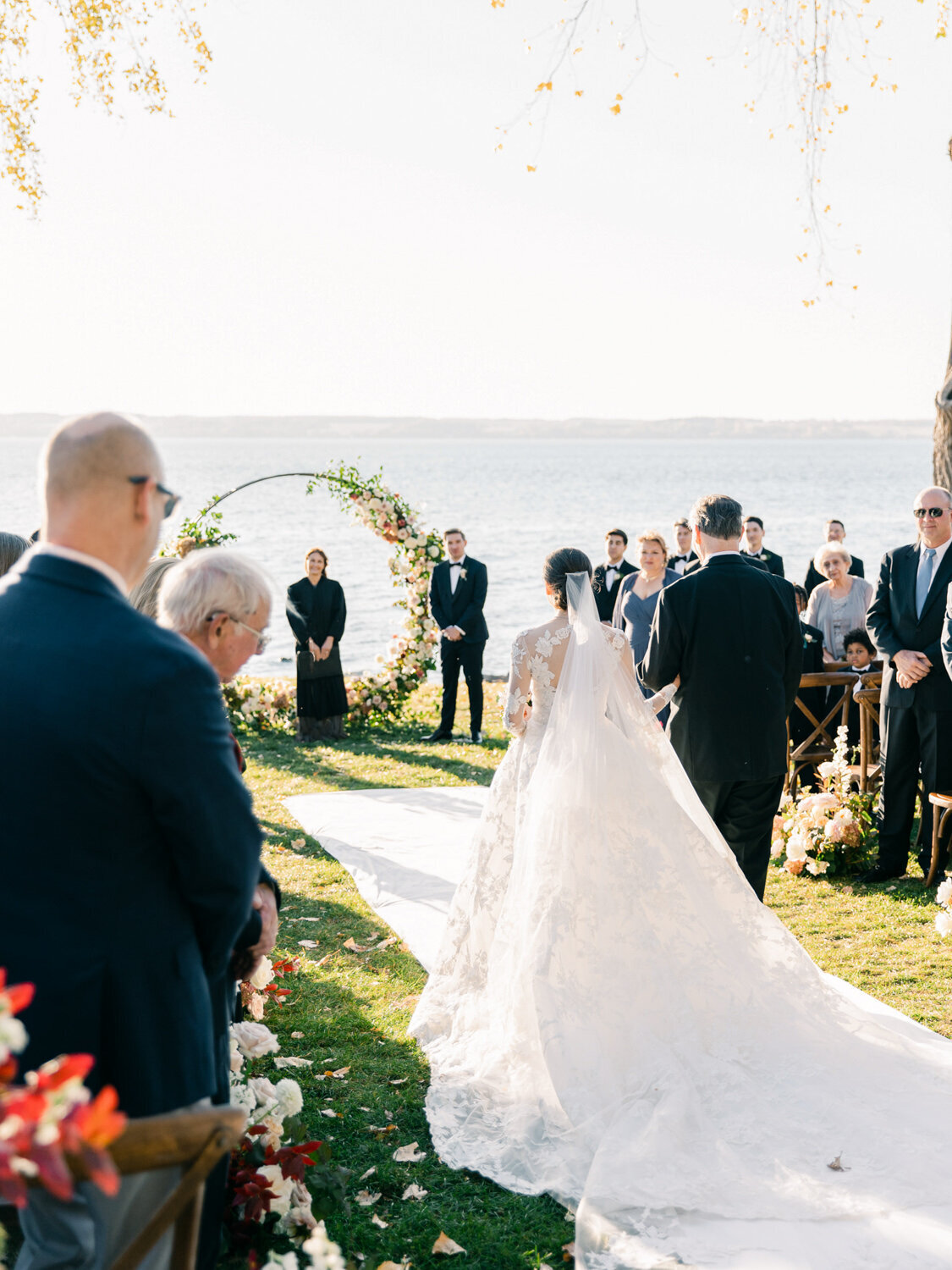 Back of bride and groom walking down the aisle to her future husband. Finger Lakes view in the background.