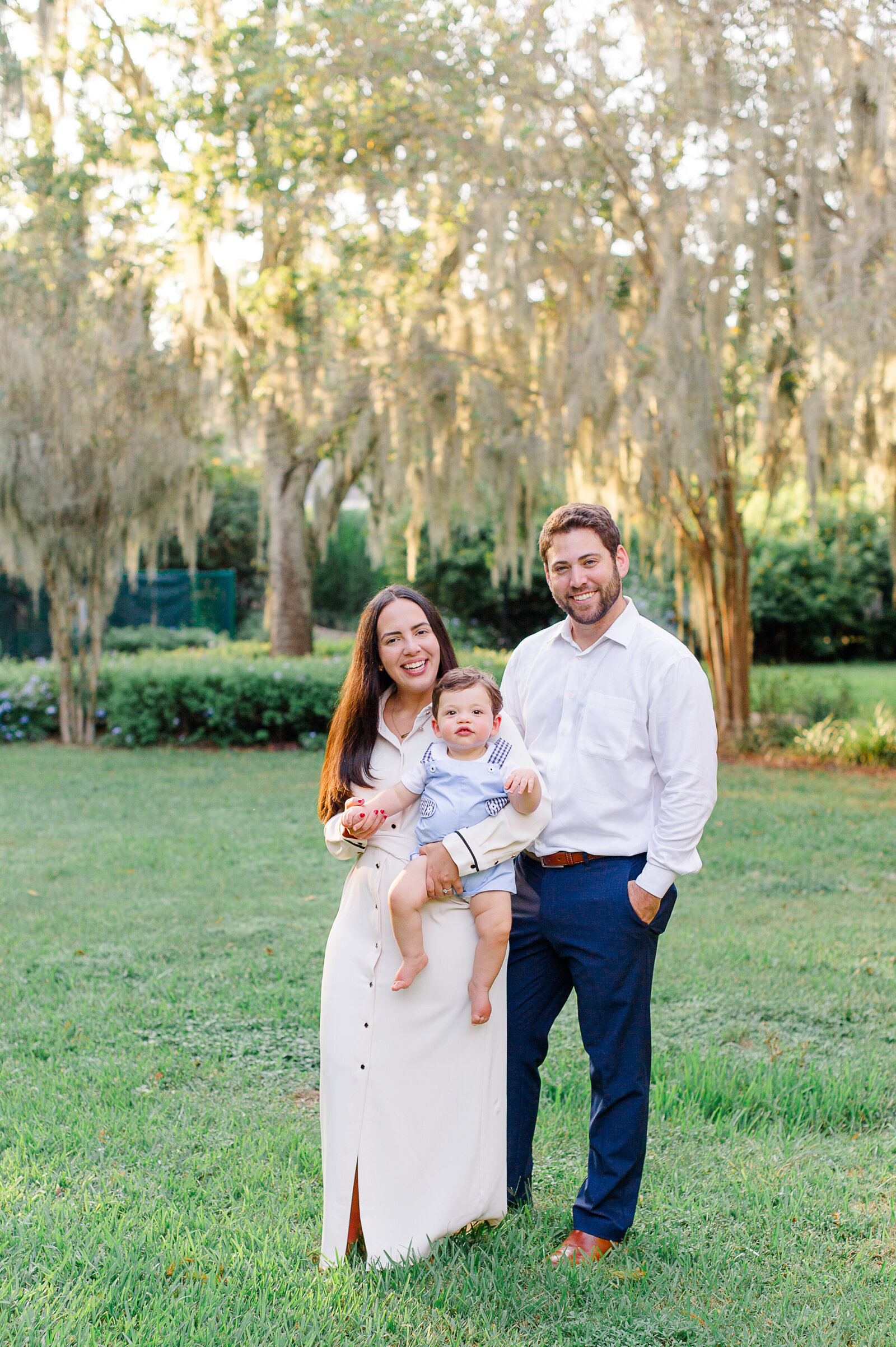 Winter Park family photographer captures a beautiful portrait of a family of three smiling at the camera