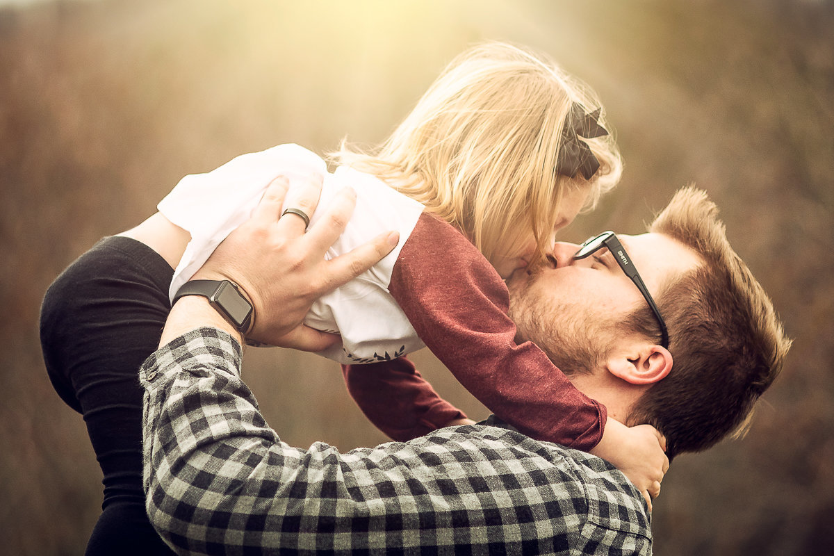 daddy lifts little girl