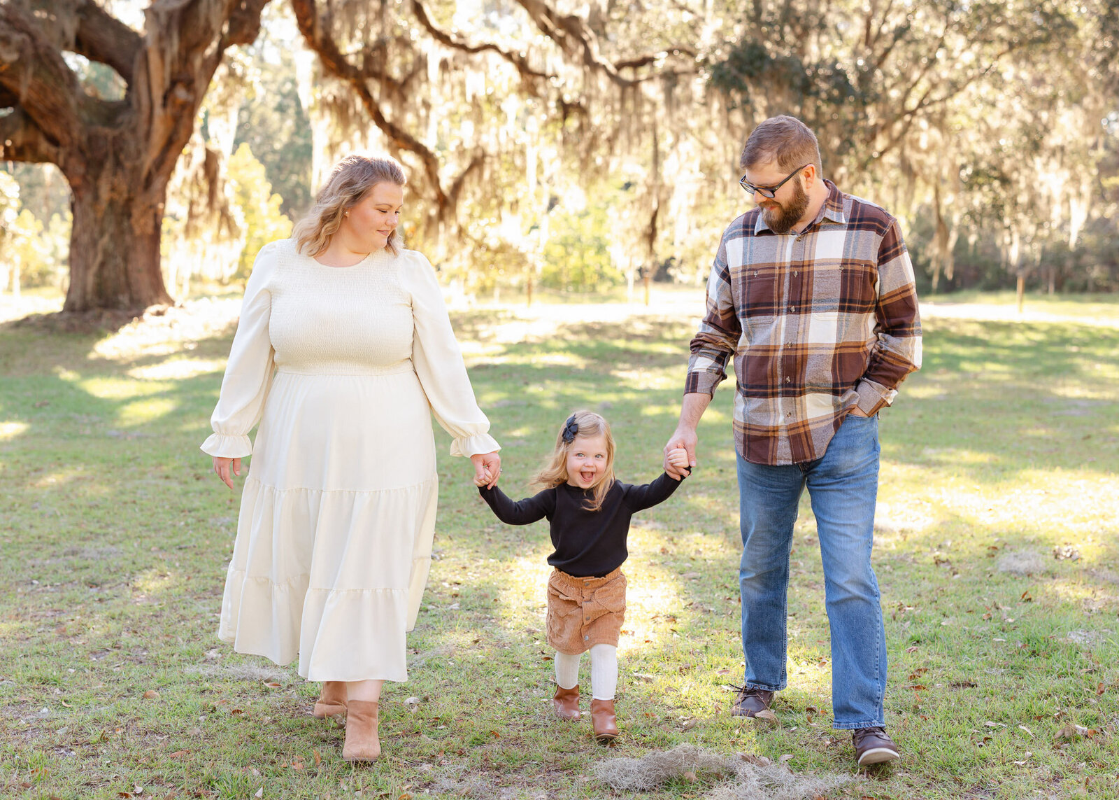 Family of 3 walking  holding hands in Savannah GA