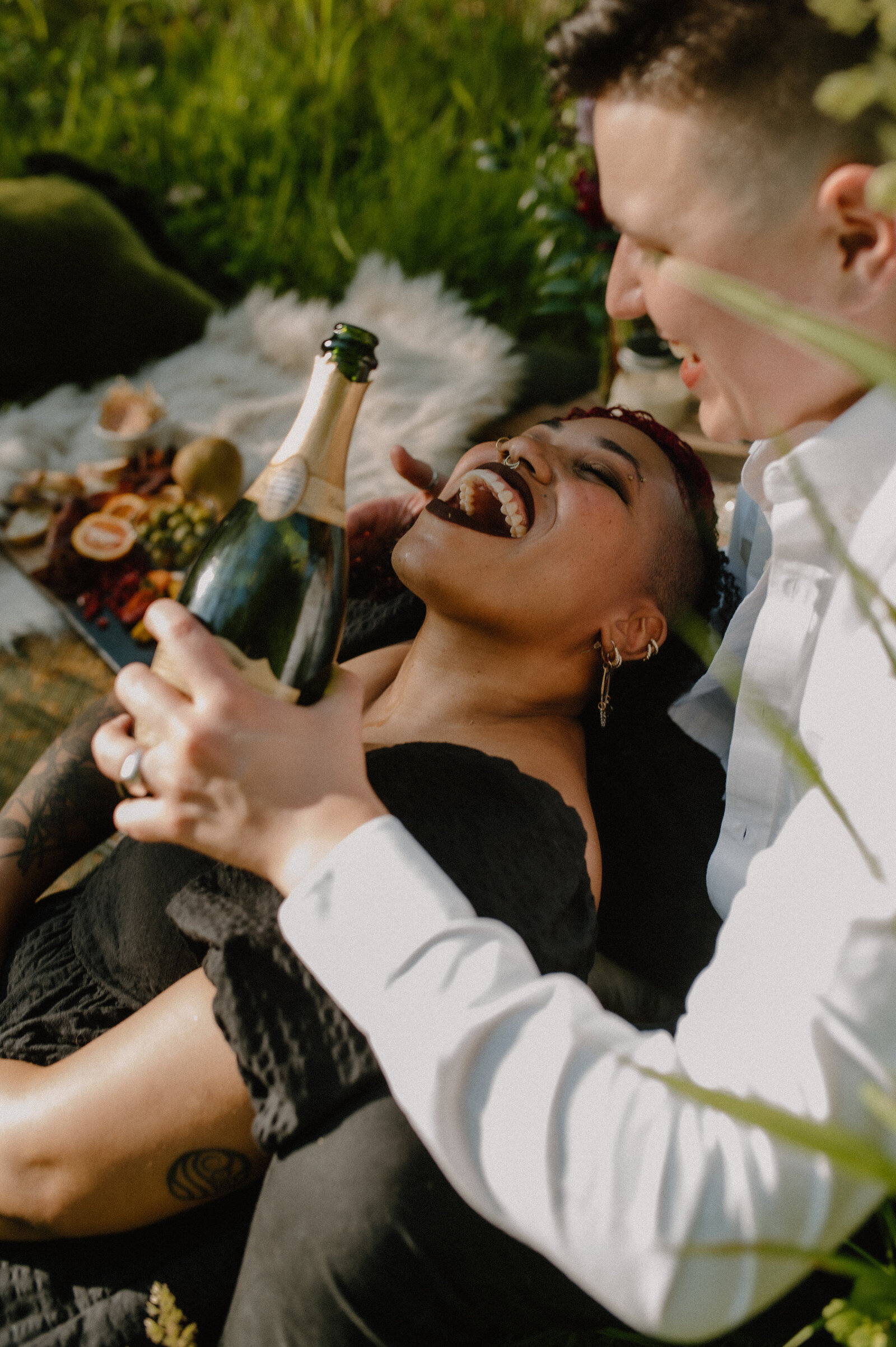 fruit and champagne engagement session with two women laughing