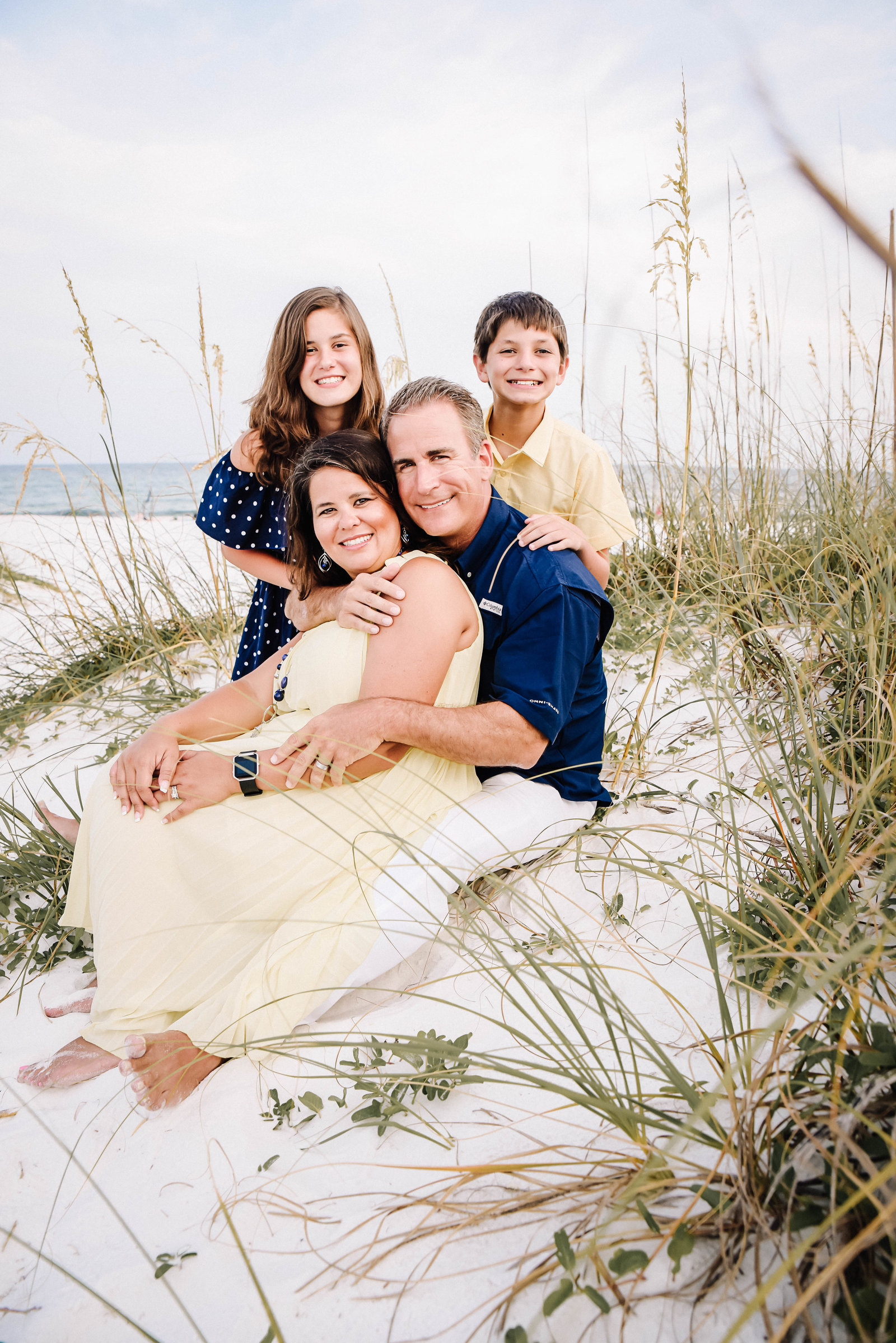 Family sitting on the white sand  beaches in Destin, FLorida
