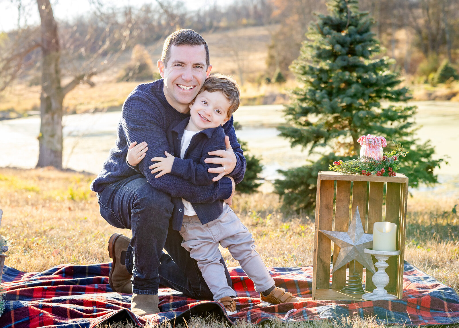 Holiday photo of hugging father and son at a Sussex County, New Jersey Christmas tree farm.
