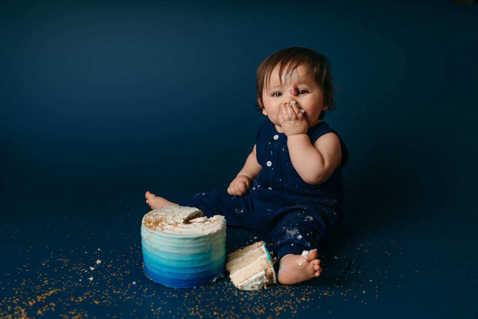 boy on navy eating cake during first birthday photo session in St. Petersburg