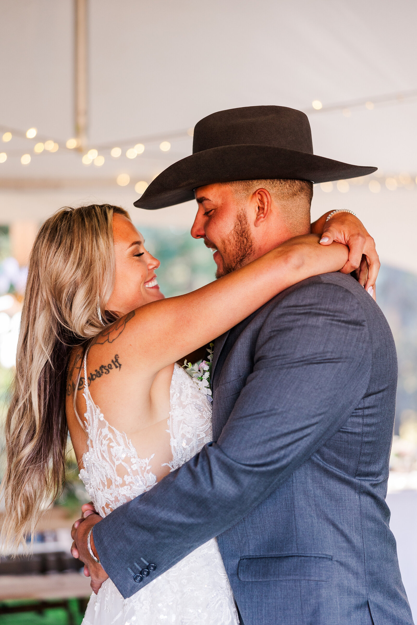 Bride wraps her arms around grooms neck as they share their first dance as a married couple together in arrowhead co