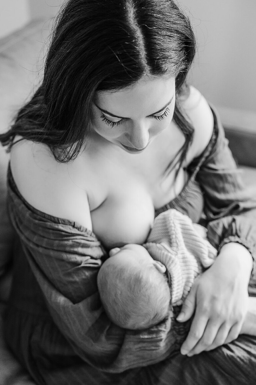 black and white portrait of mother nursing new baby