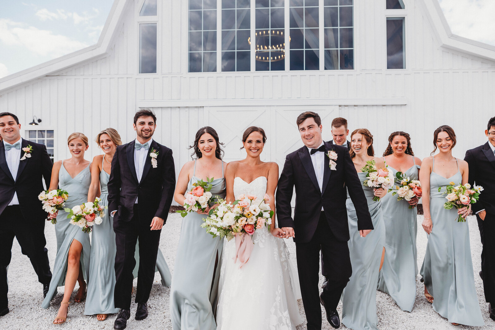 wedding party walking towards the camera in happy celebration of the couple