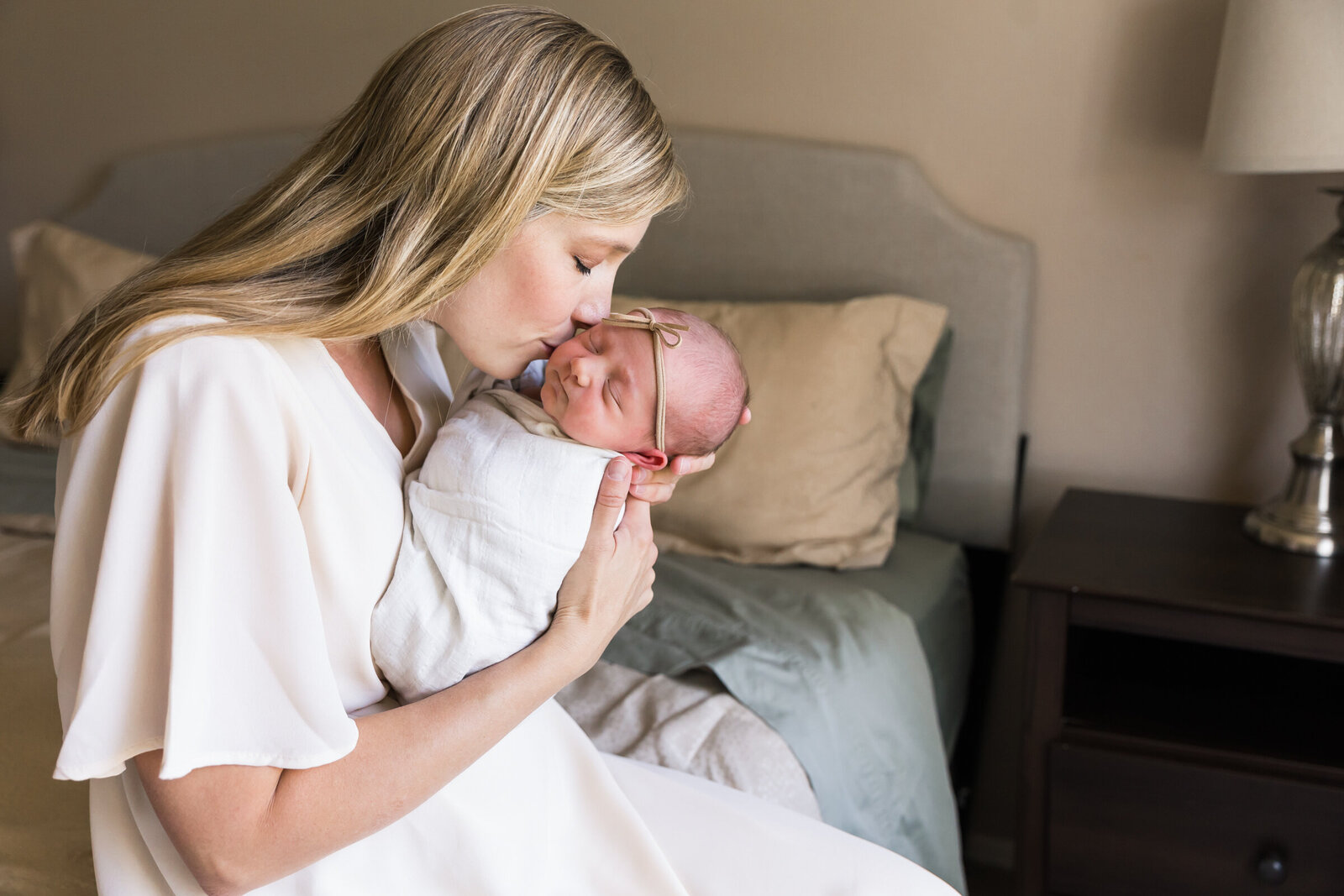 mom kisses newborn baby in Scottsdale lifestyle newborn session
