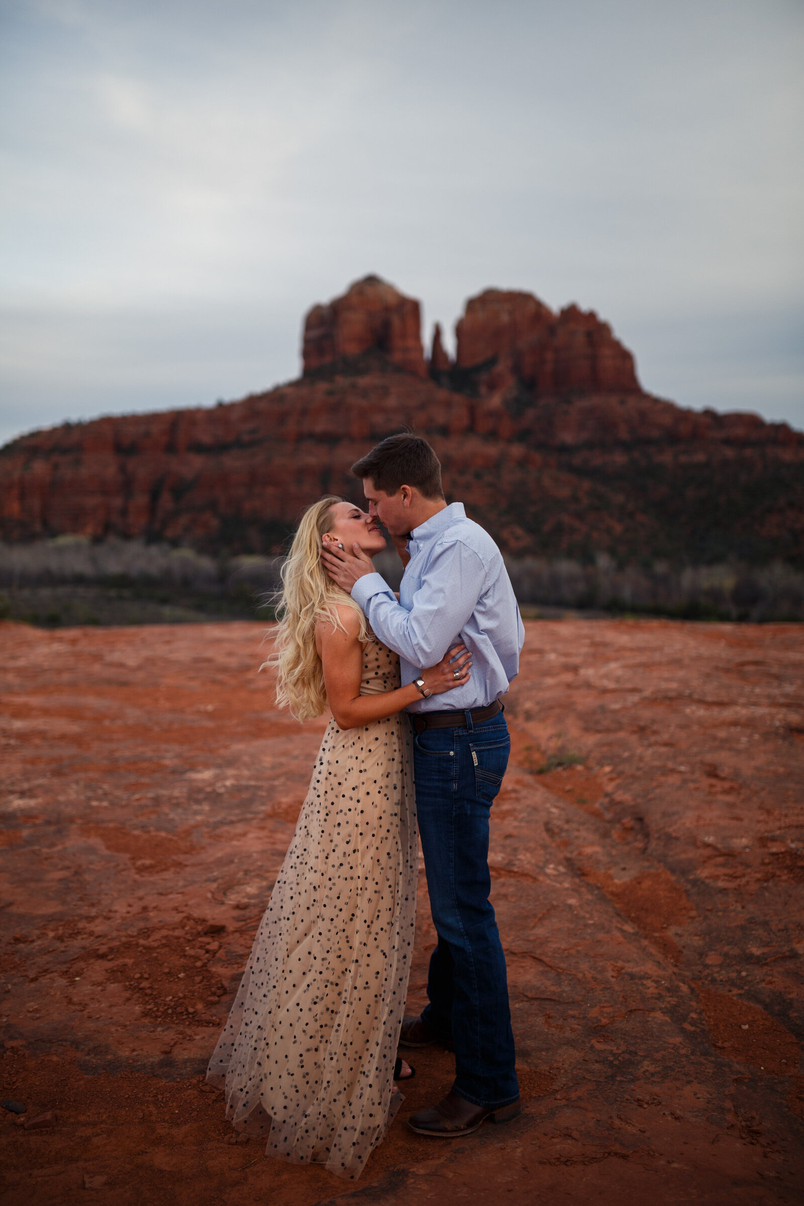 couple kissing during engagement photos near bell rock