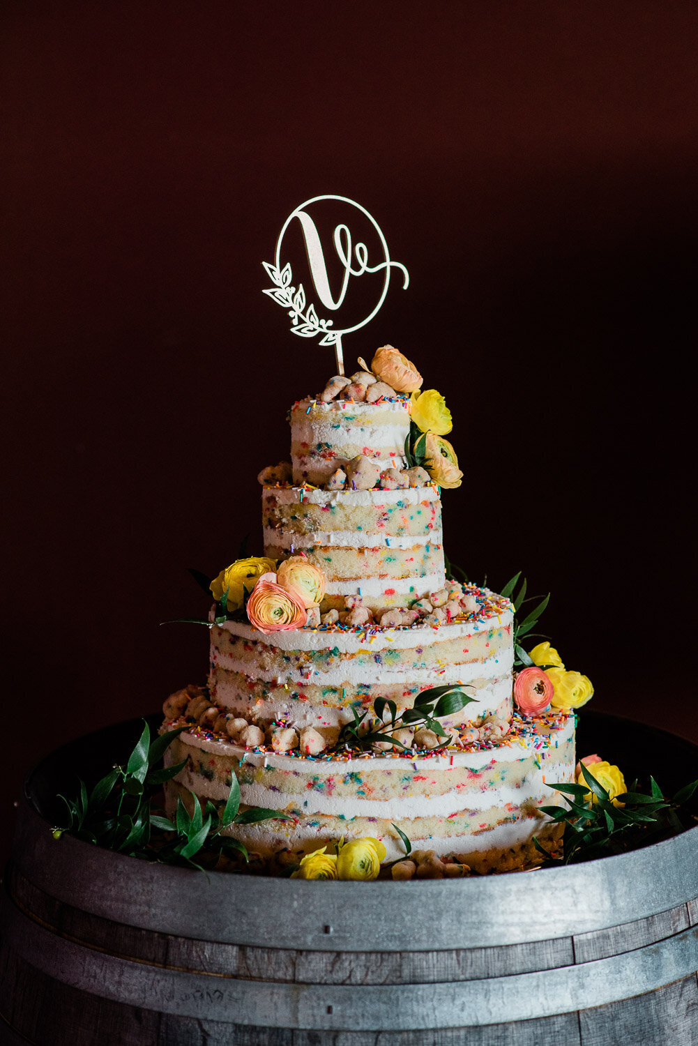 funfetti four tiered wedding cake with initial topper