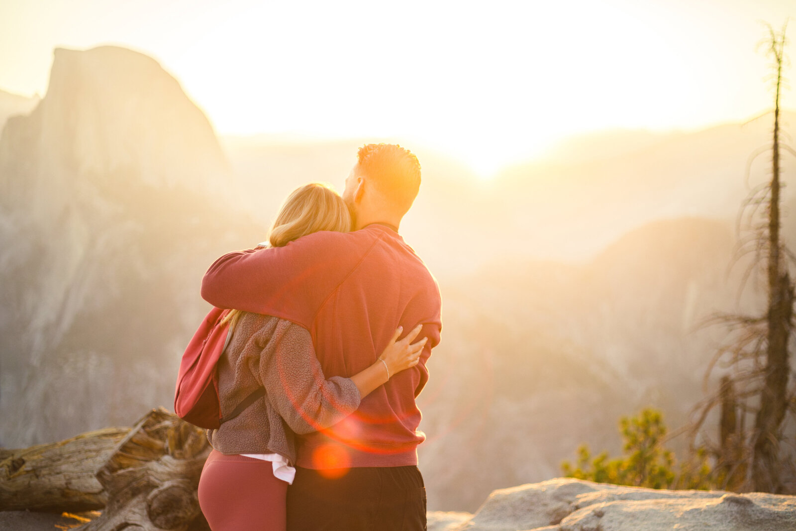 A wedding proposal between two hikers at sunrise in front of Half Dome in Yosemite National Park.