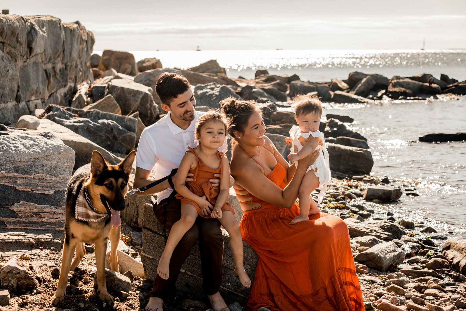 family smiling  and having funwith their dog on the beach