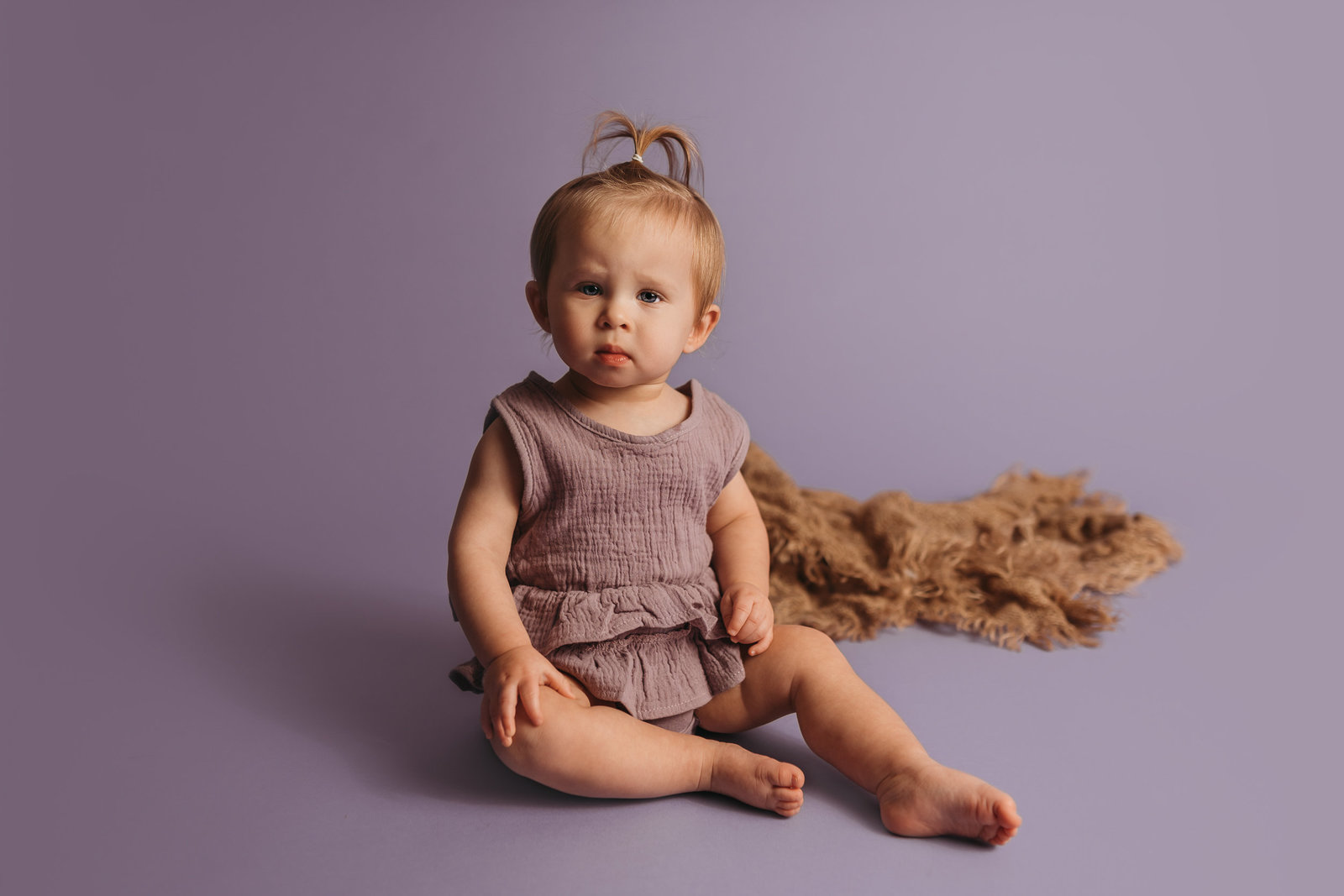little girl sitting on purple during milestone session at studio in Tampa