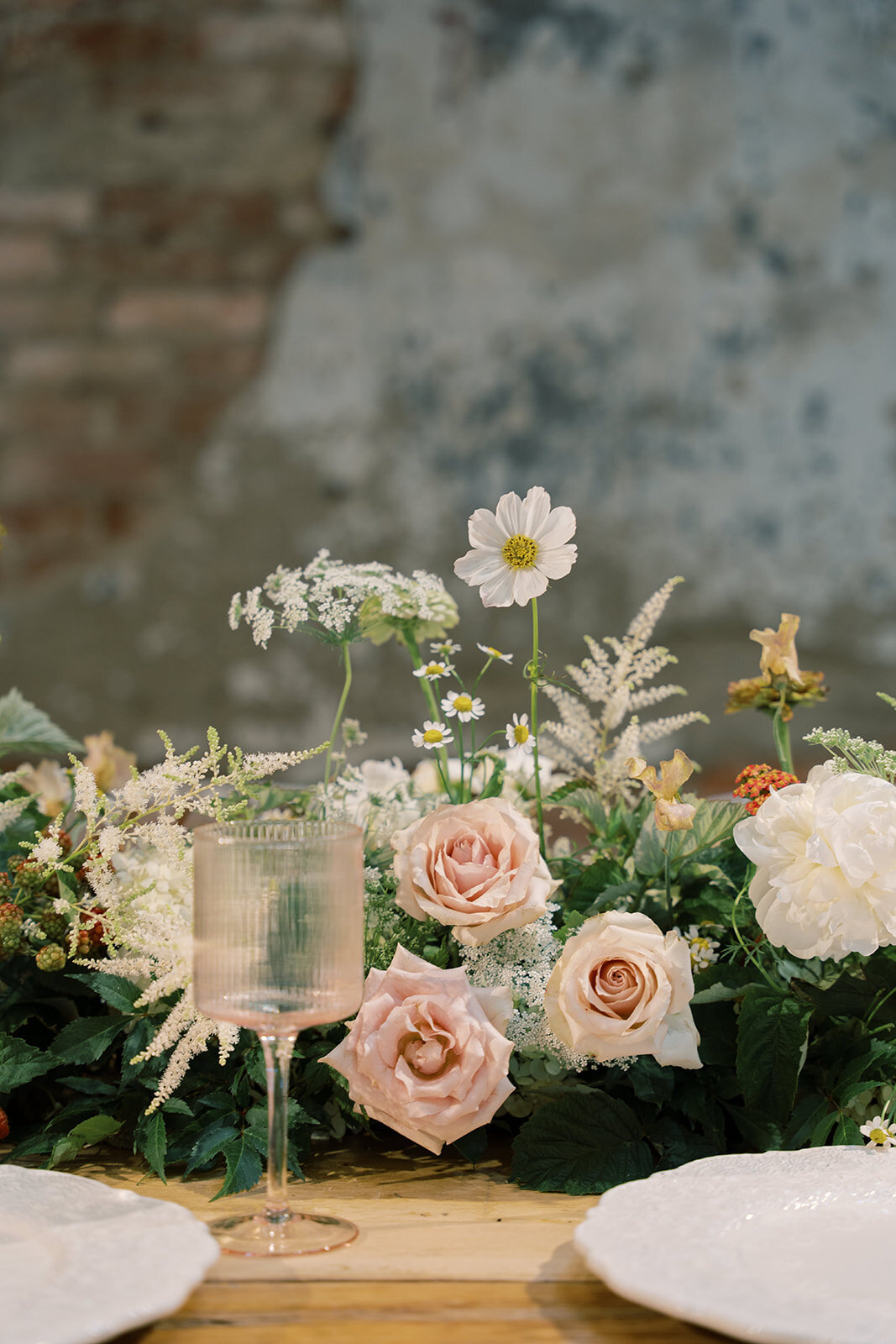 Meadow of florals down a long guest table with blush harden roses, white cosmos, queen anns lace, white astilbe and white peony.
