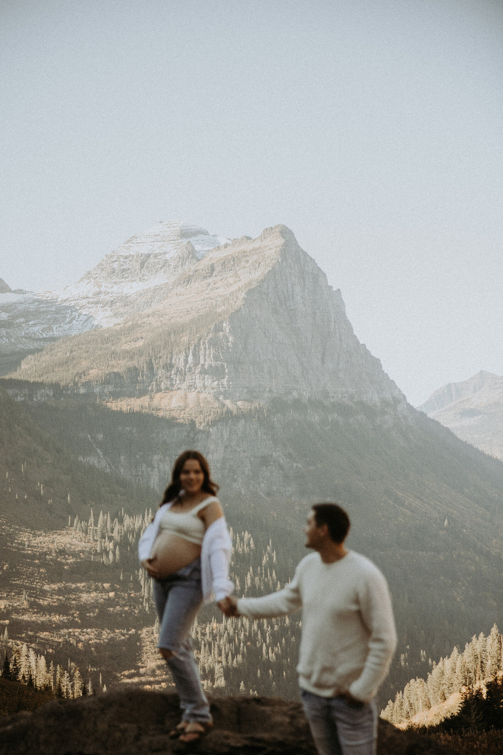 maternity photo of couple holding hands with mom to be holding her belly