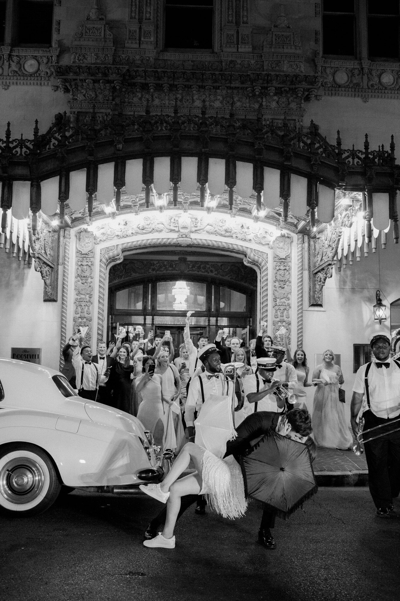 bride and groom standing on street with guests