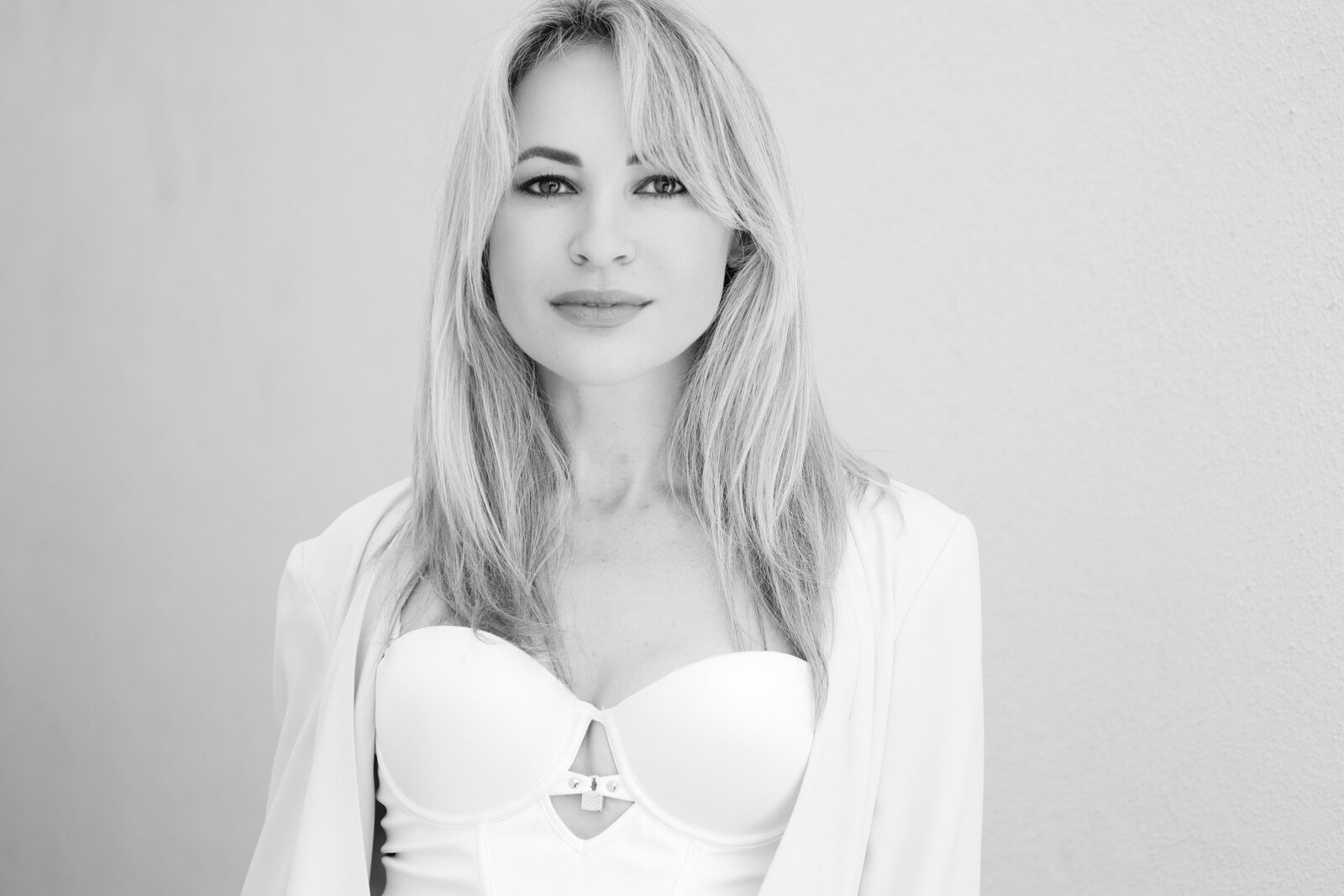 Austin headshot photographer Svetlana Frolova in a white blazer looking in the camera