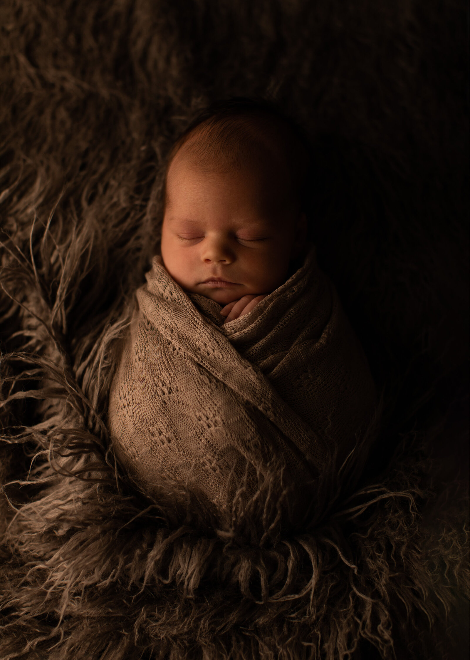 newborn in a potato sack in dark flokati