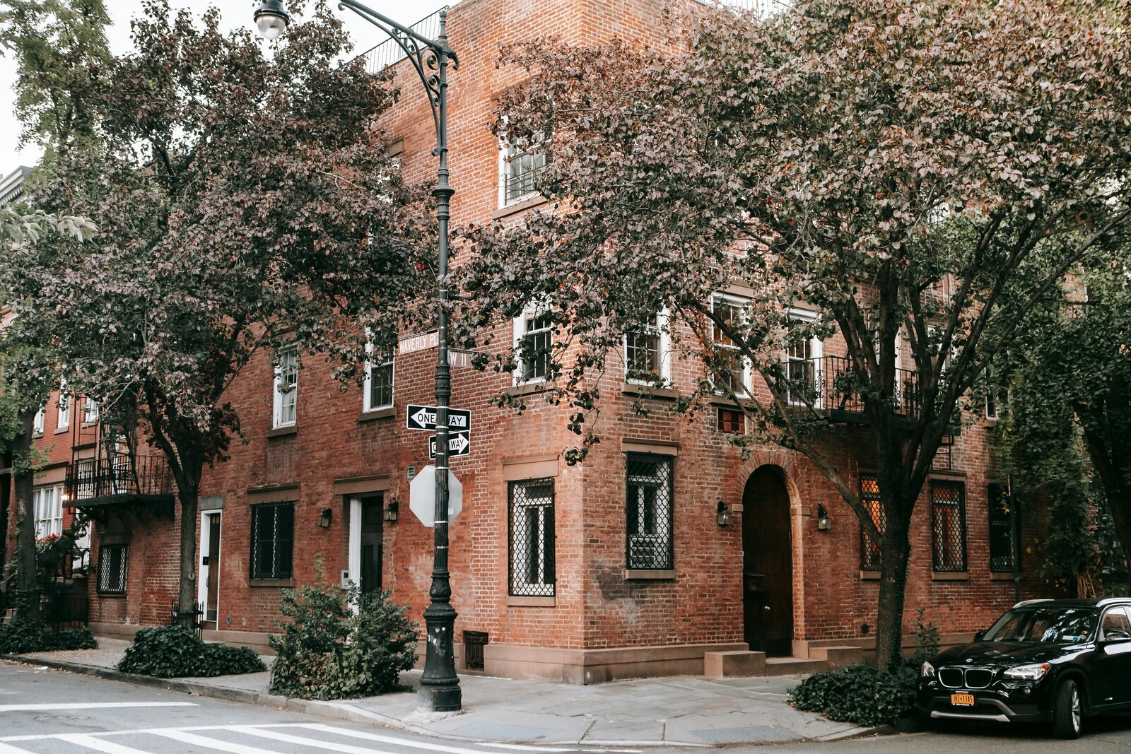 Brownstone townhouse in NYC with a tree-lined street and classic architecture.