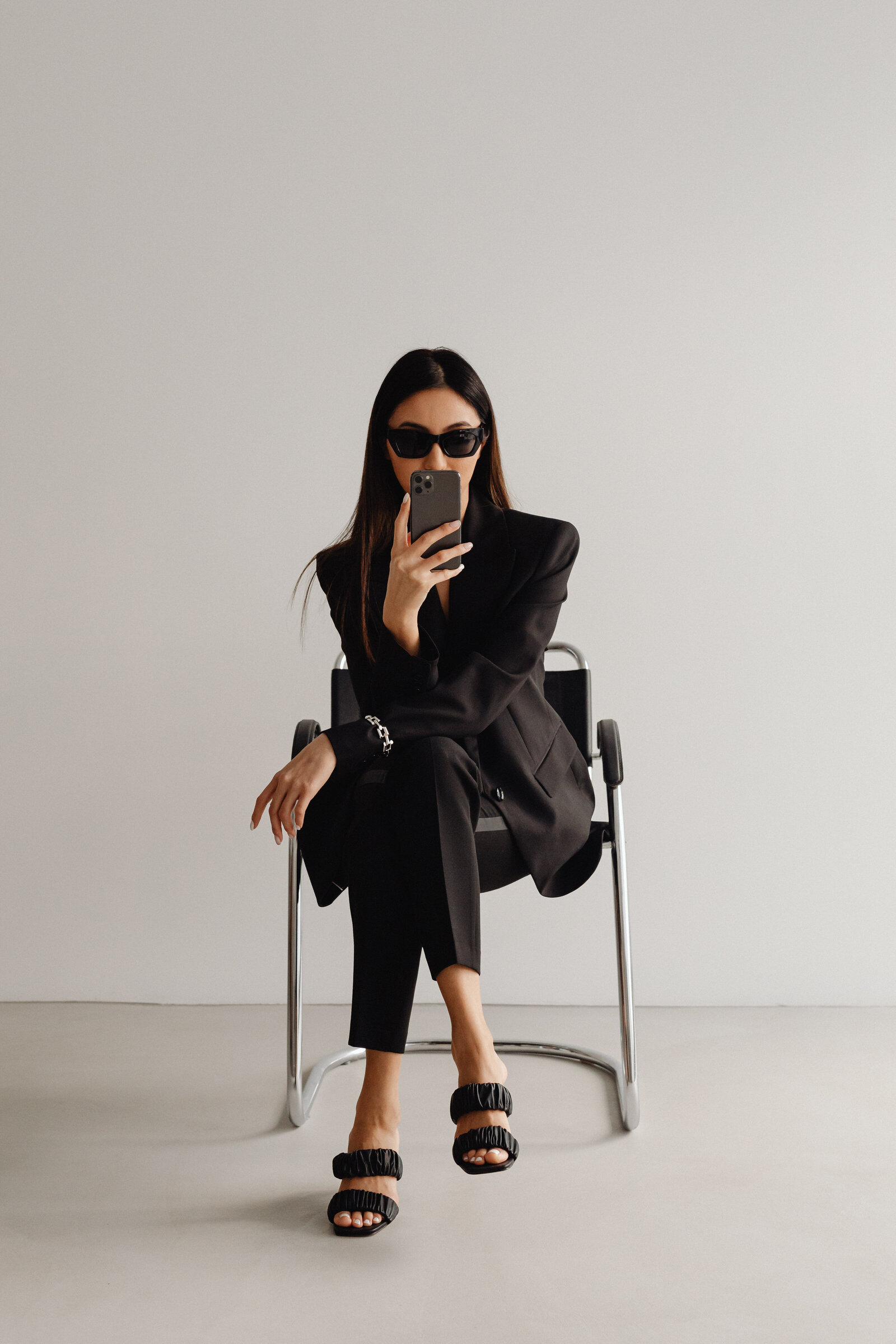 kaboompics_dark-classy-aesthetic-fashion-beautiful-asian-female-entrepreneur-in-black-suit-technology-and-devices-iphone-laptop-airpods-30037