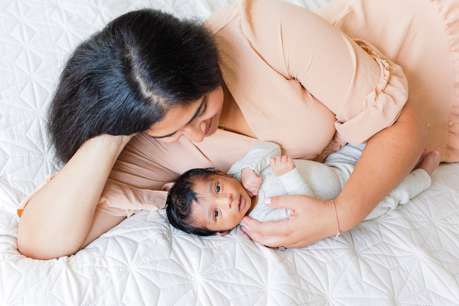 A DC mom laying in bed with her newborn son.