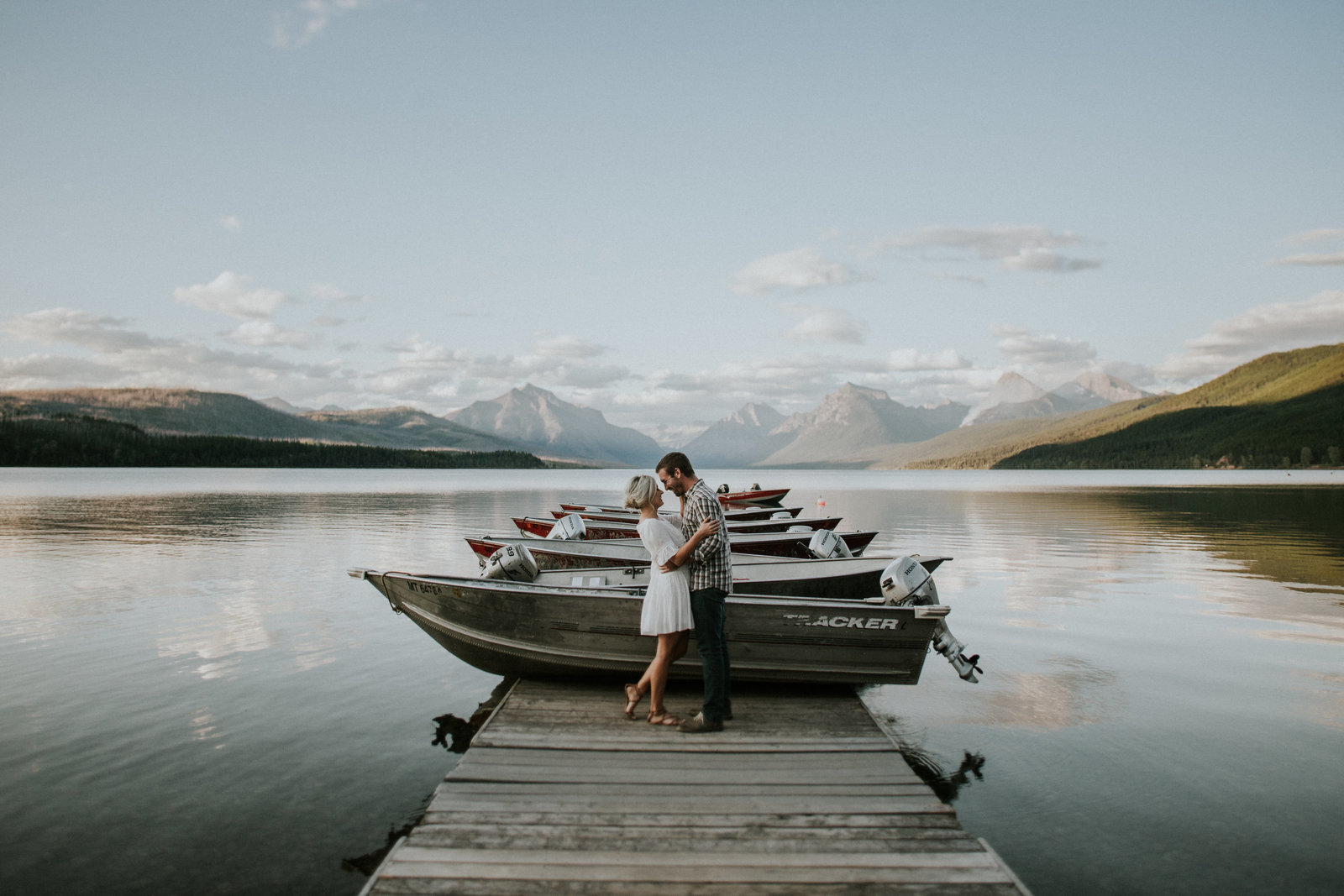 Glacier National Park Engagement Couple Embracing on Dock