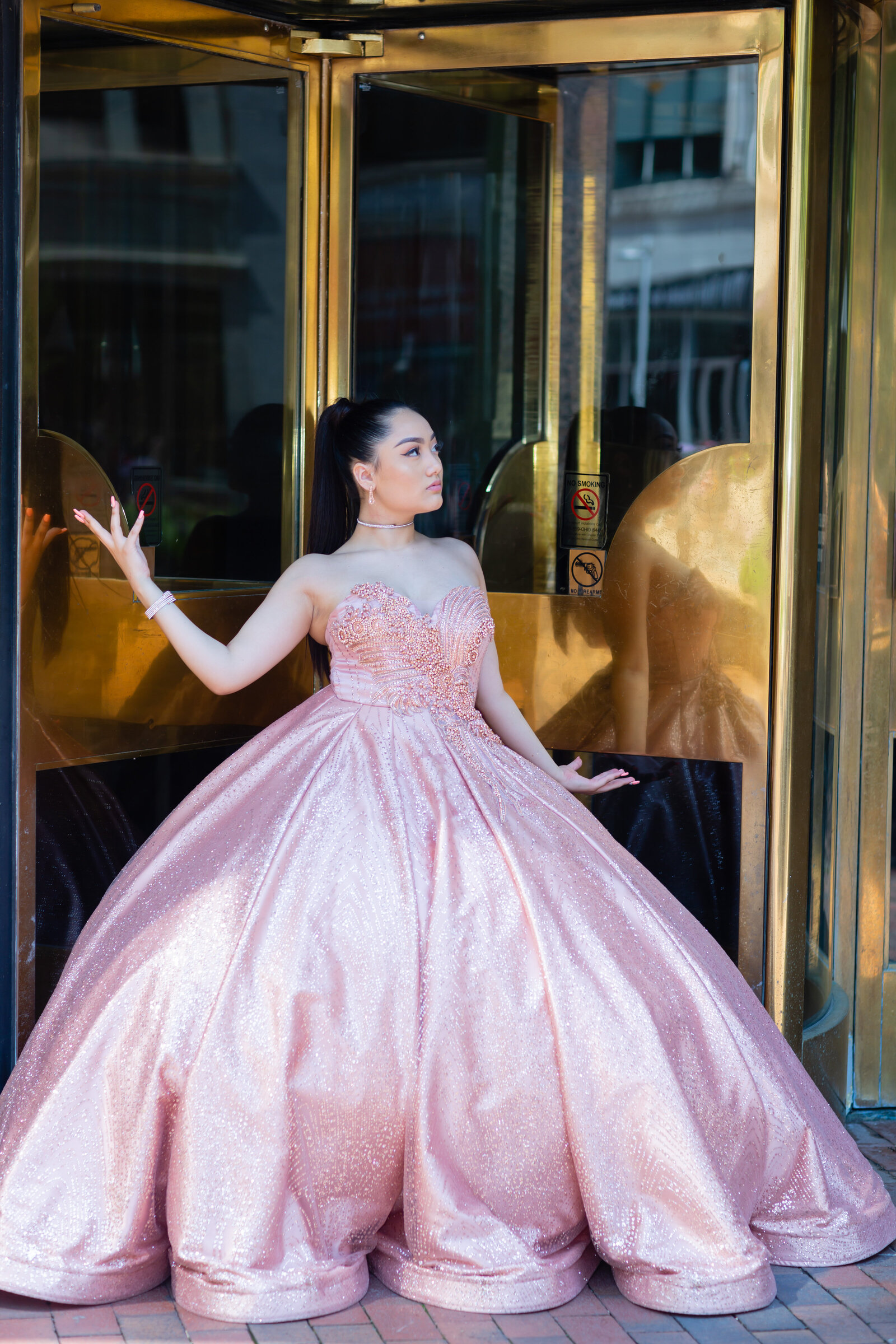 Rosalyn Kinsey showcasing her vibrant personality with a playful pose during her quinceañera photoshoot at Cleveland’s iconic Playhouse Square.